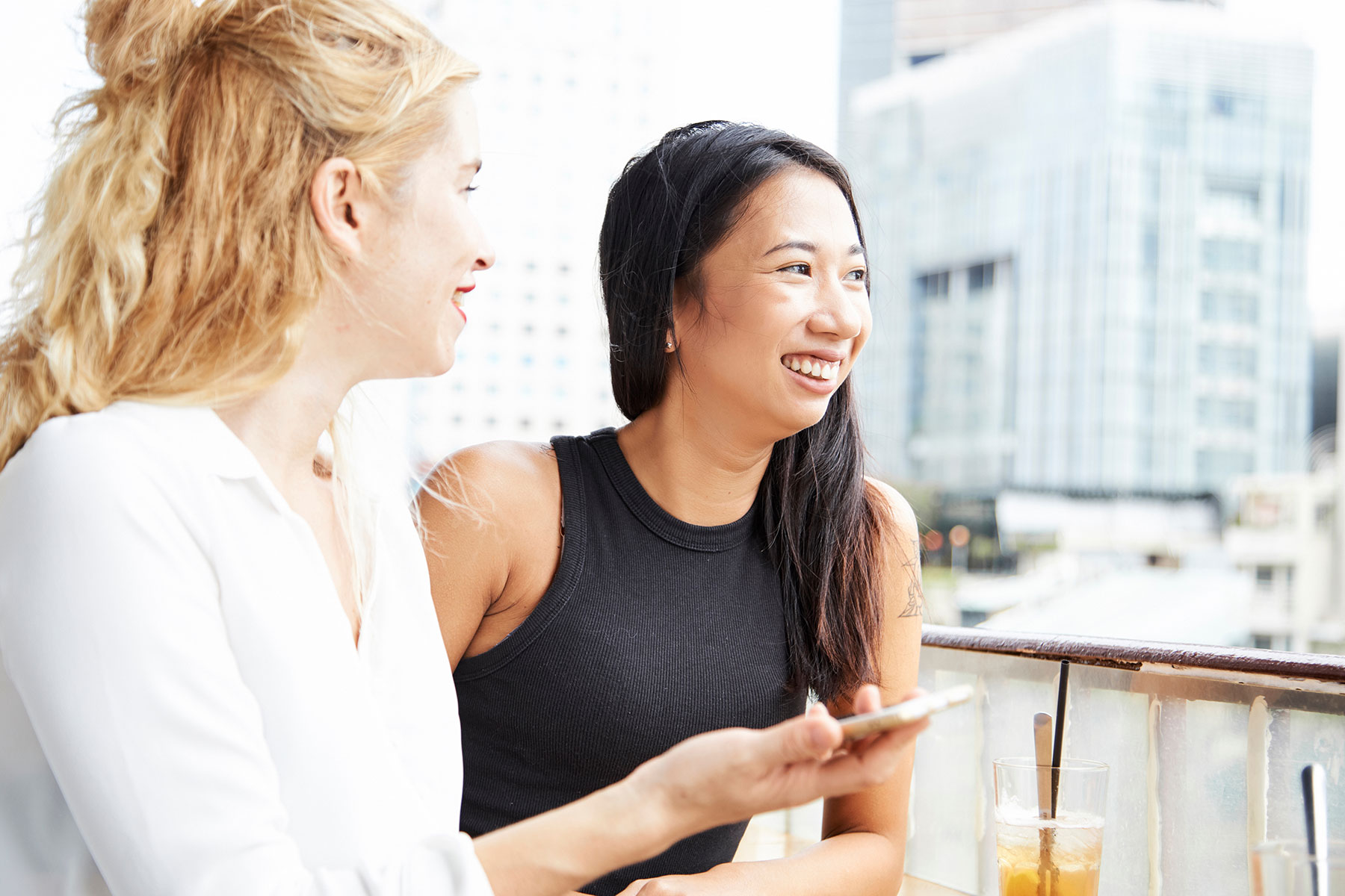 Two women peering from an outdoor dining table